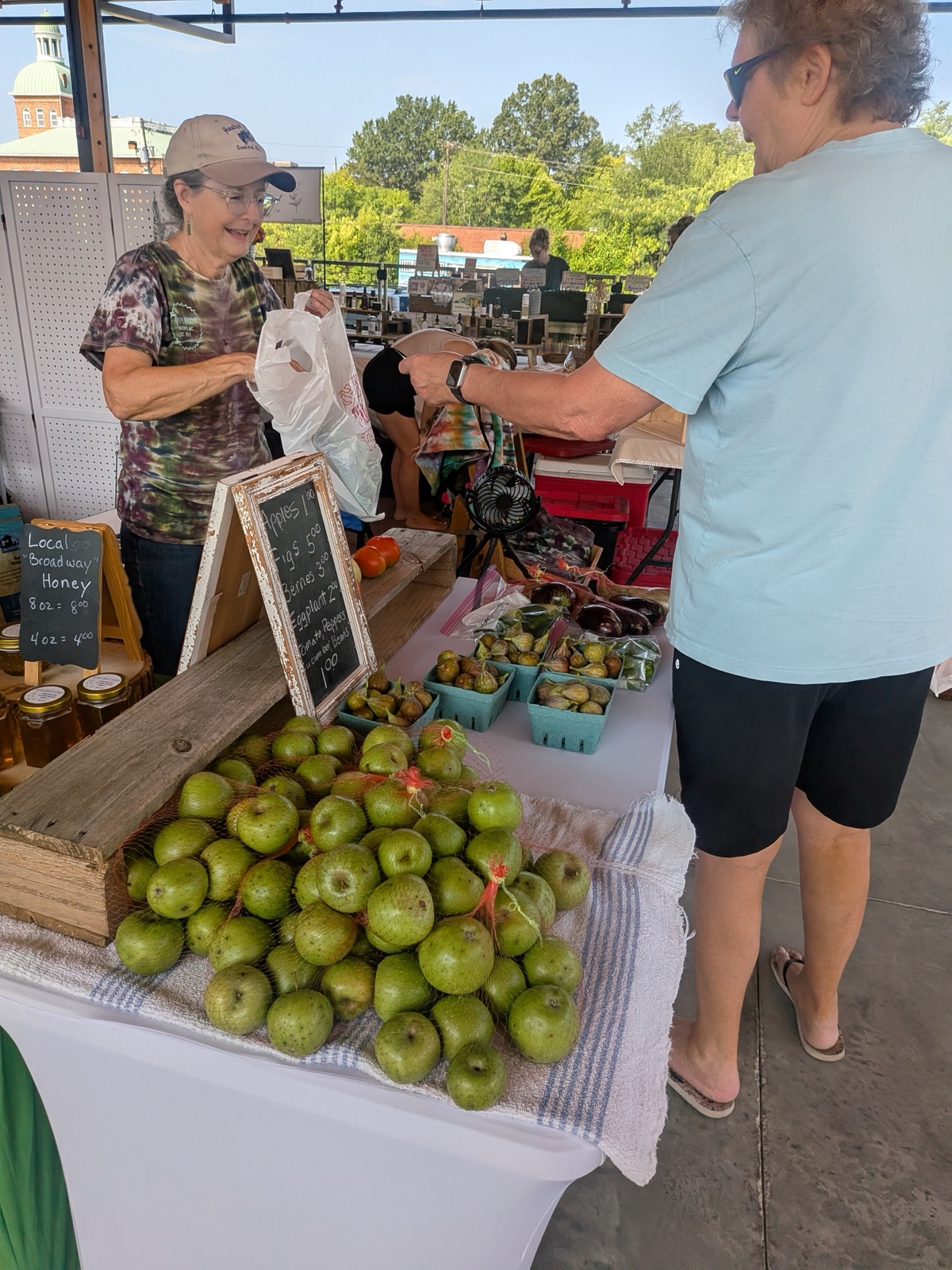 A shopper visiting Hunter Farm’s fruit and honey display