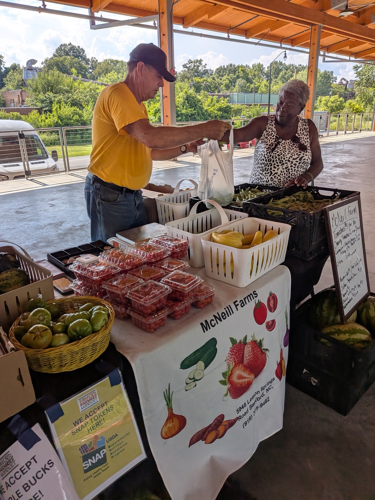 A customer shopping for fresh produce at the McNeil Farms stand