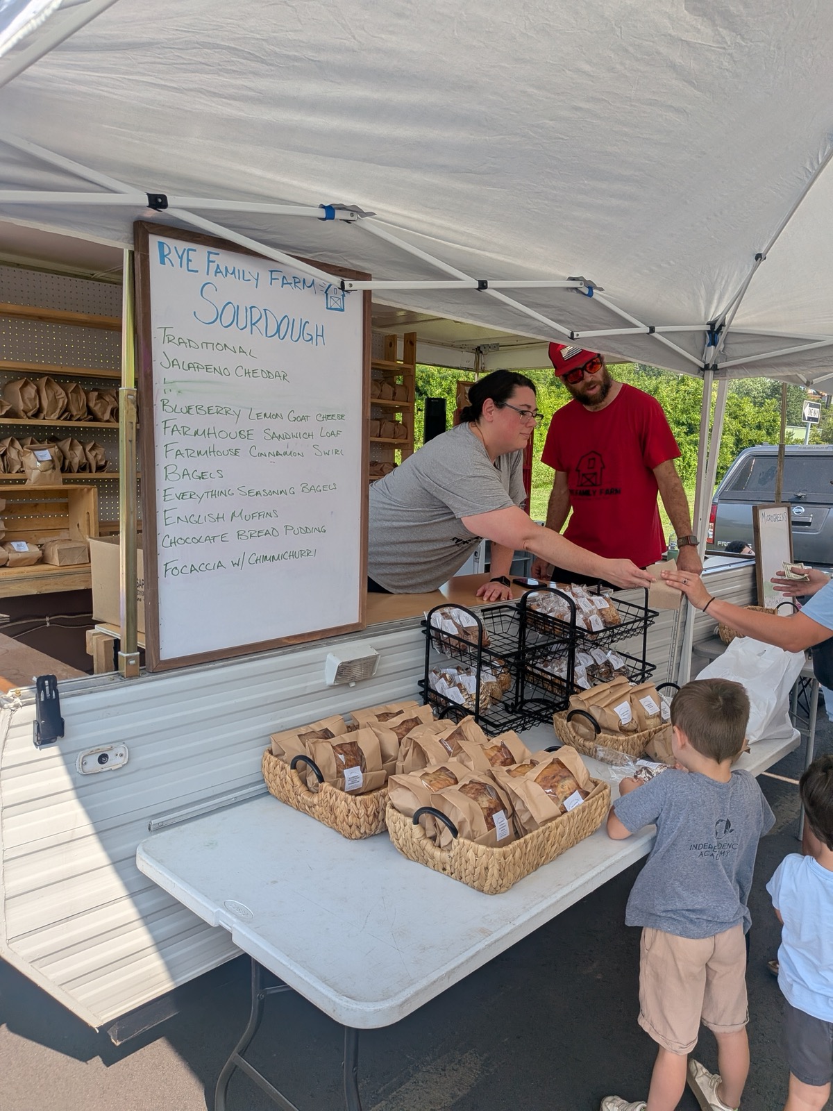 Rye Family Farm’s sourdough stand with vendors and shoppers